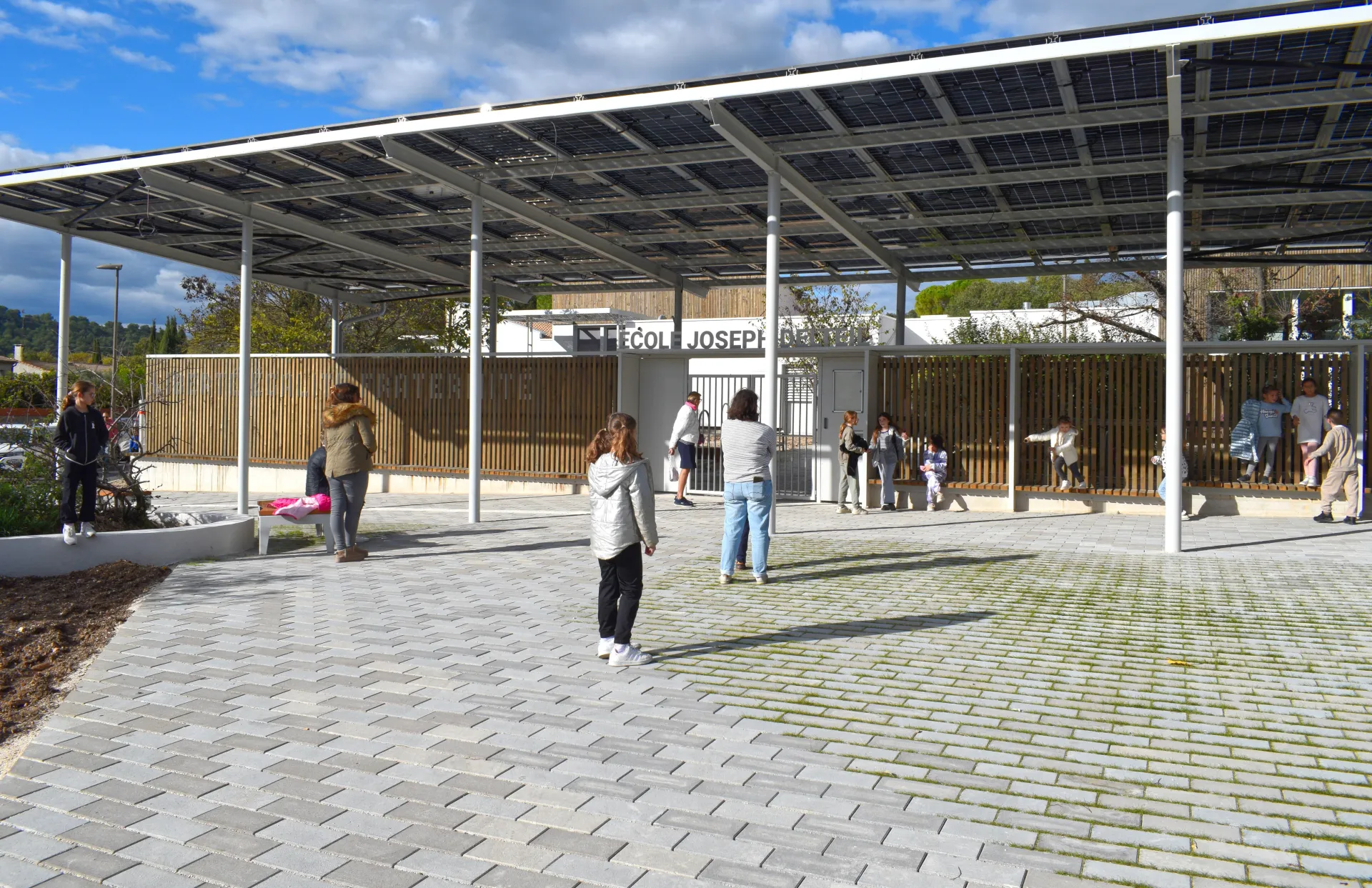 Des enfants et leurs parents sur le nouveau parvis de l'école