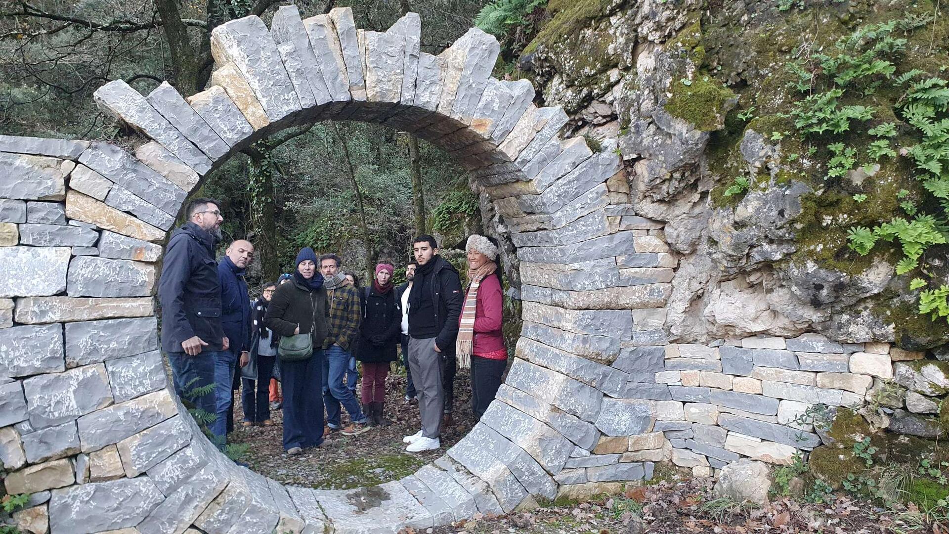 Les participants vus à travers le moongate, cercle de pierre sèche de 2 m de diamètre intérieur
