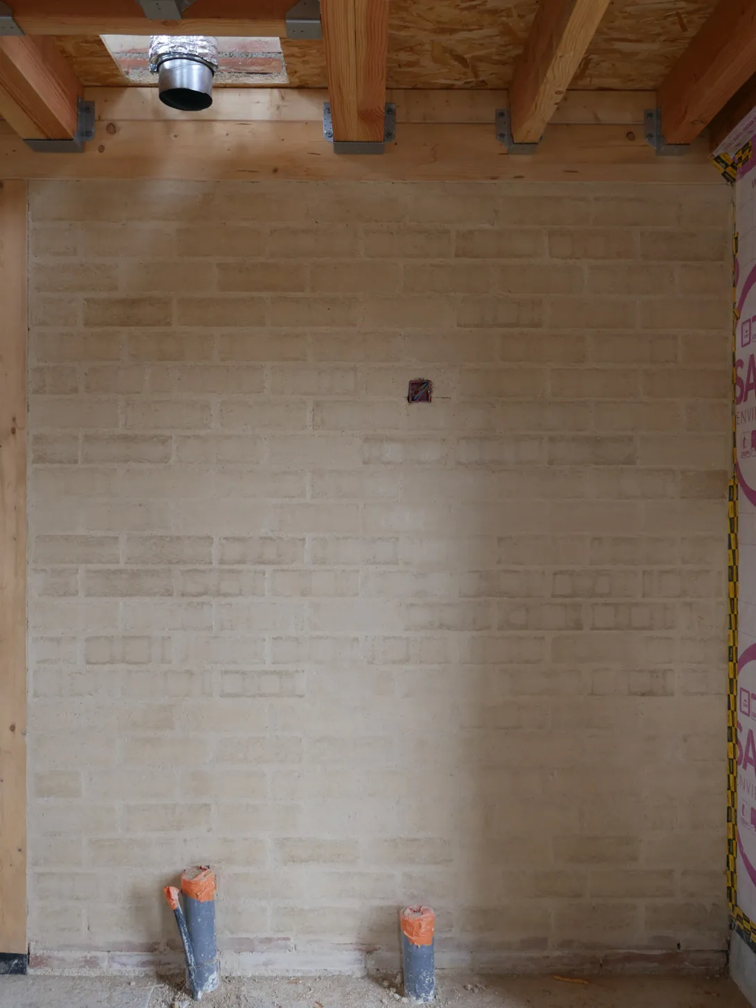 Mur en brique de terre crue avec finition