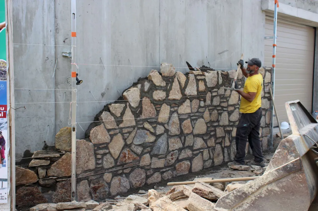 Les soubassements en béton sont revêtus de pierre