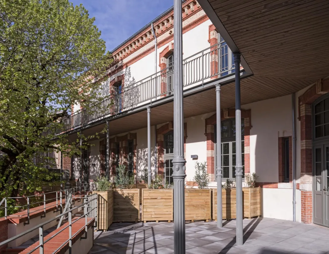 Des poteaux en fonte réemployés supportent la coursive